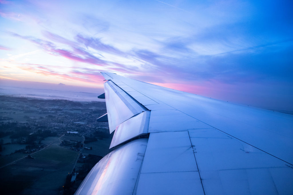 Plane wing taking off over sunset | Family on Standby