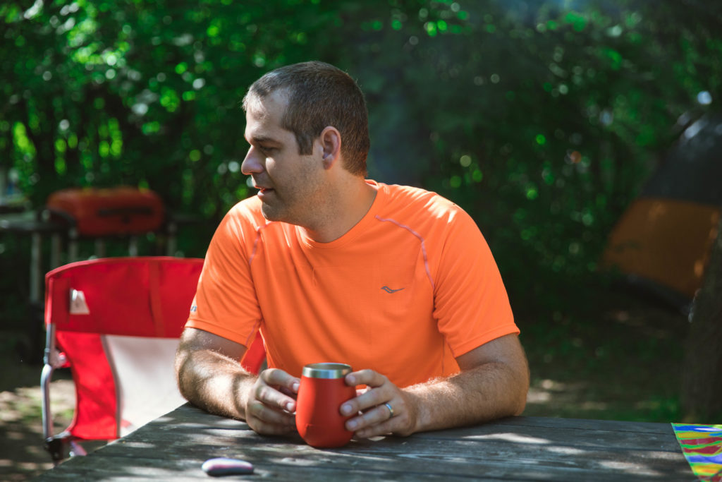 dad drinks coffee out of his Yeti mug while tent camping