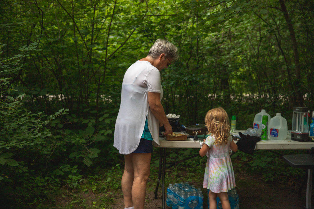 4 year old prepares lunch with grandma while tent camping