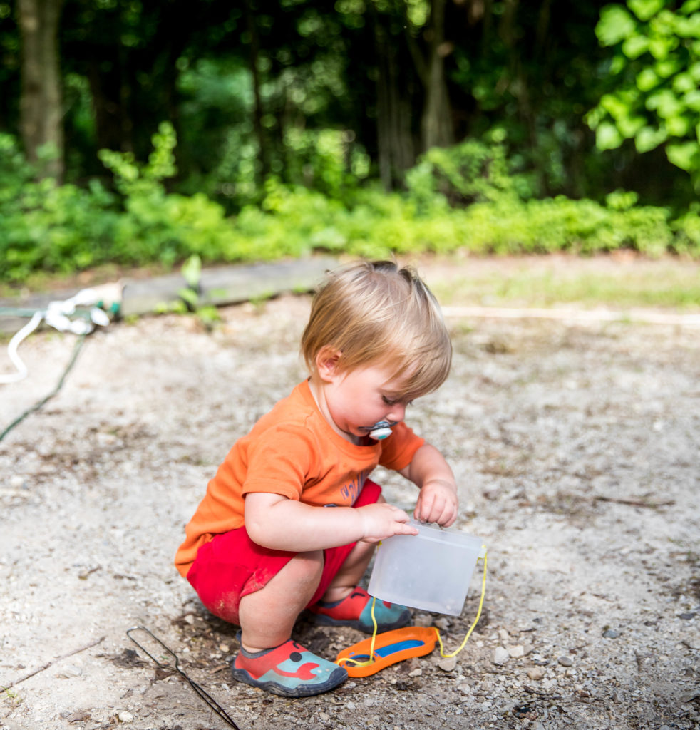 One year old playing with a bug catching kit | camping essentials for kids