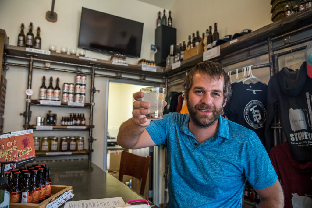 Man holding up a cocktail at Stoneyard Distillery in Dotsero, CO | A Harvest Host experience