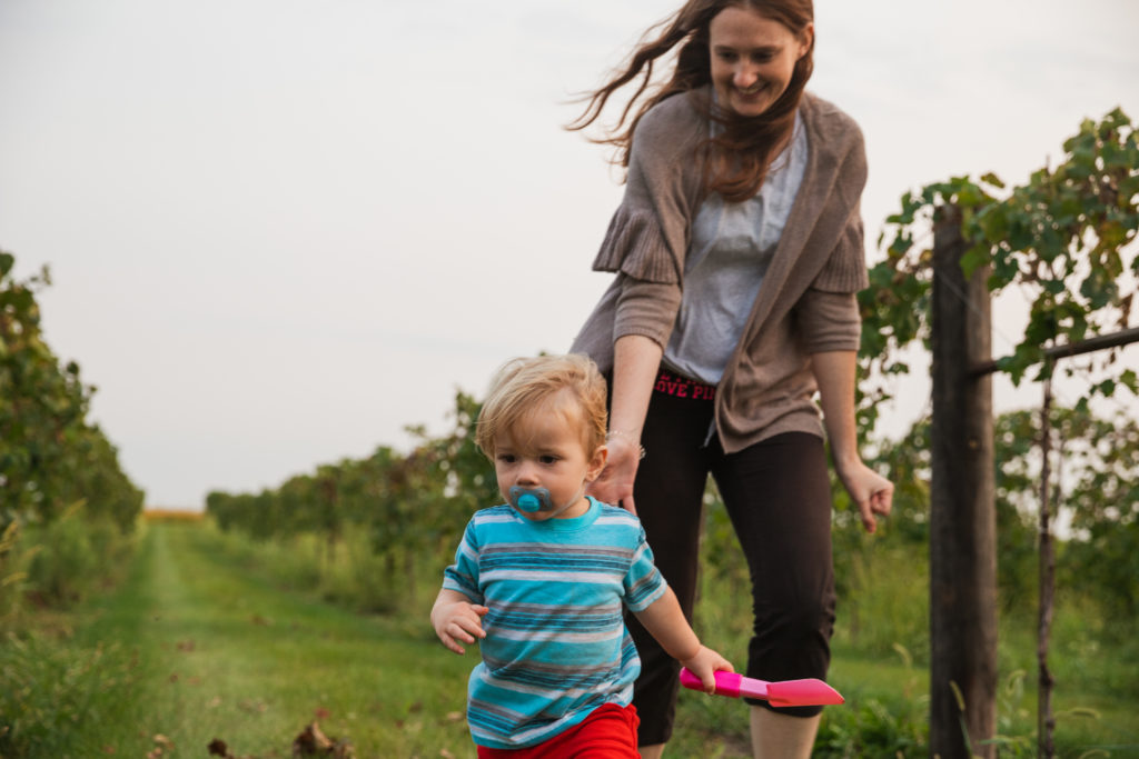 Mom and son running through vineyards and Wooden Wheel Vineyards during a Harvest Host stay