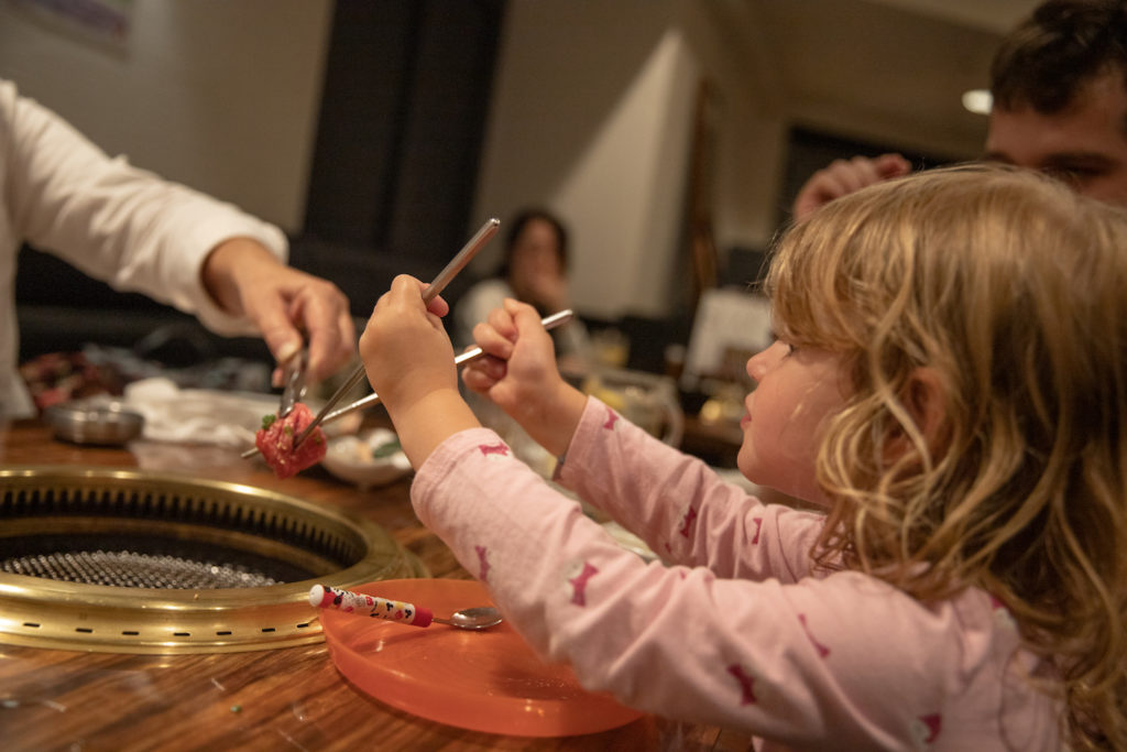3 year old cooking meat from a restaurant in Tokyo