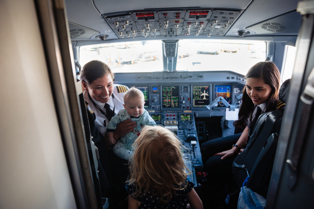 two kids with two female pilots after flights lands