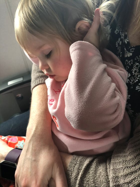 2-year-old sleeping on the plane in her pajamas