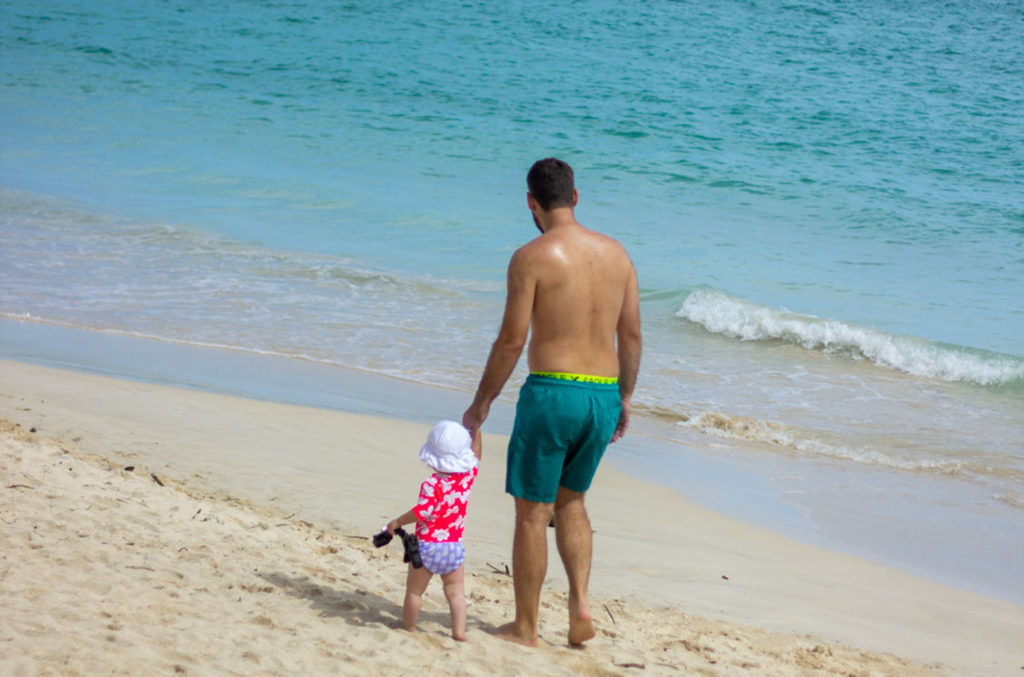 dad and toddler daughter walking the beach in hawaii | hawaii with a baby vs. toddler