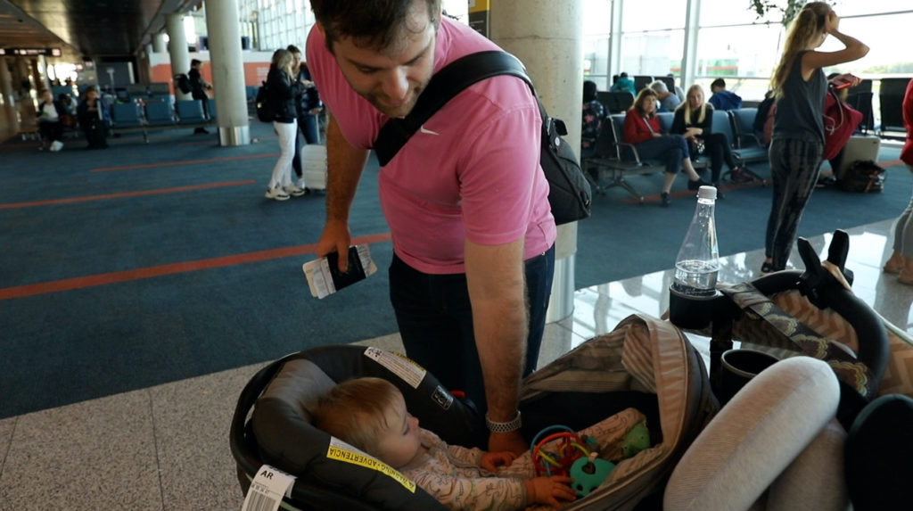 Dad and baby stroller toys at gate