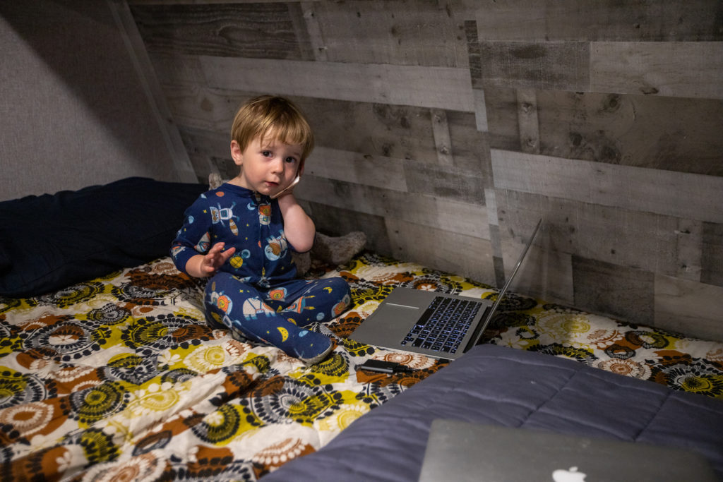 toddler pretending to work on phone and computer