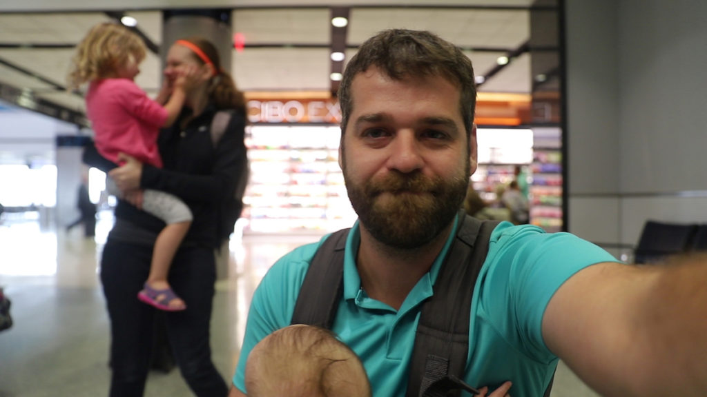 family filming for travel youtube channel at airport