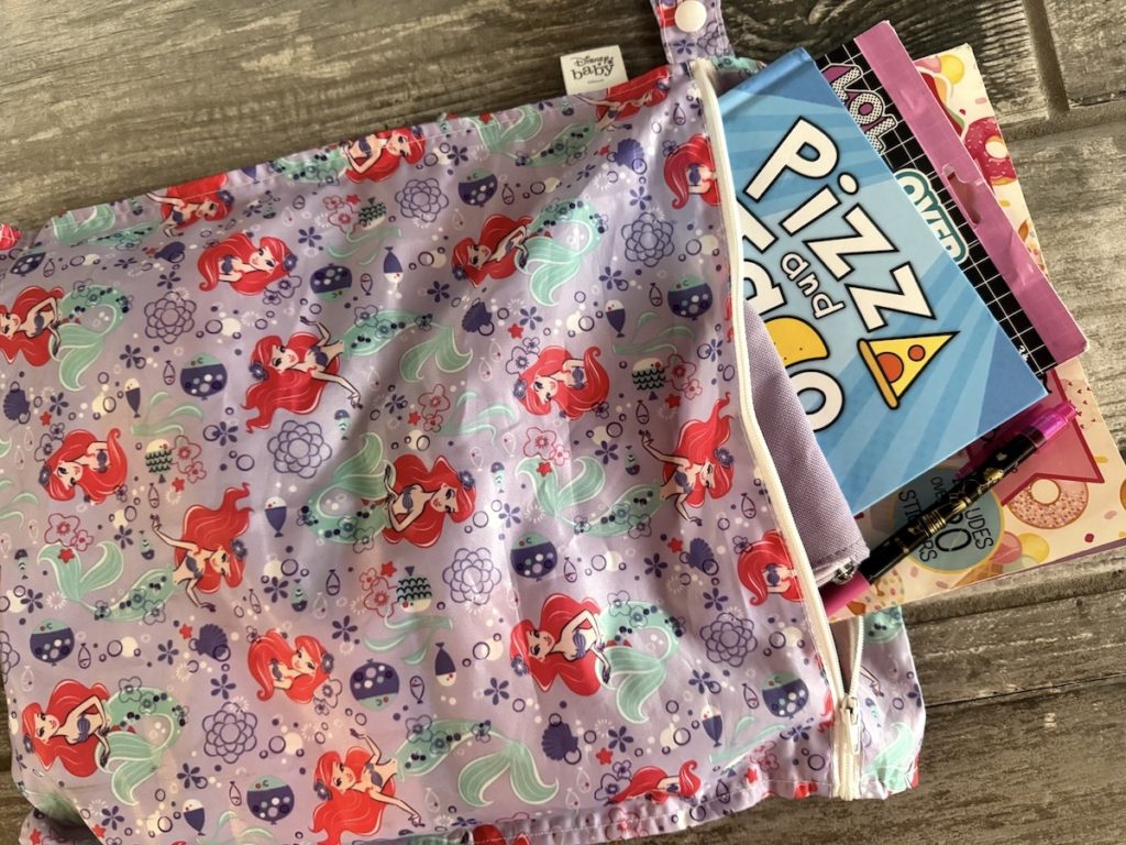 Bumkins waterproof wetbag used to store toys, books, and snacks for travel