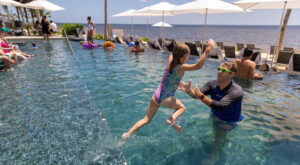 girl jumping in pool at hilton cancun all inclusive resort riviera maya